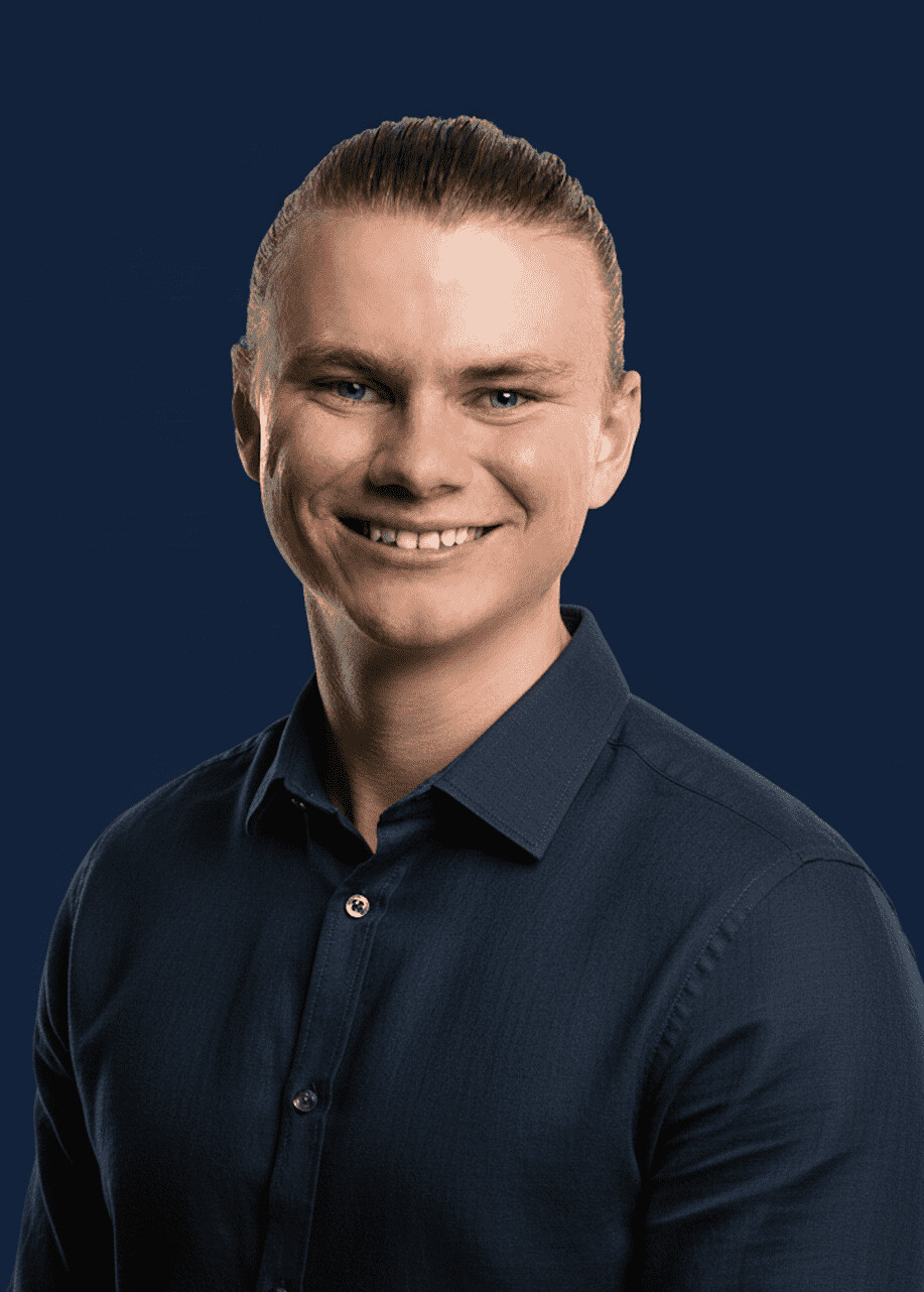 Jake Holmes, who runs Keely's walk-throughs, smiling, in a navy shirt against a navy background.